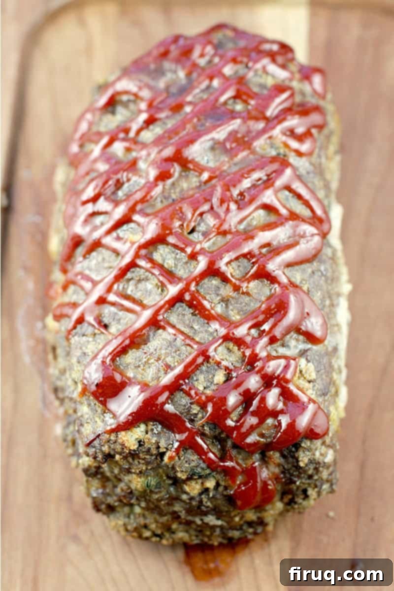 Mom's Meatloaf 12 whole cooked best meatloaf ever on a wood board showing the criss-cross ketchup mixture on top