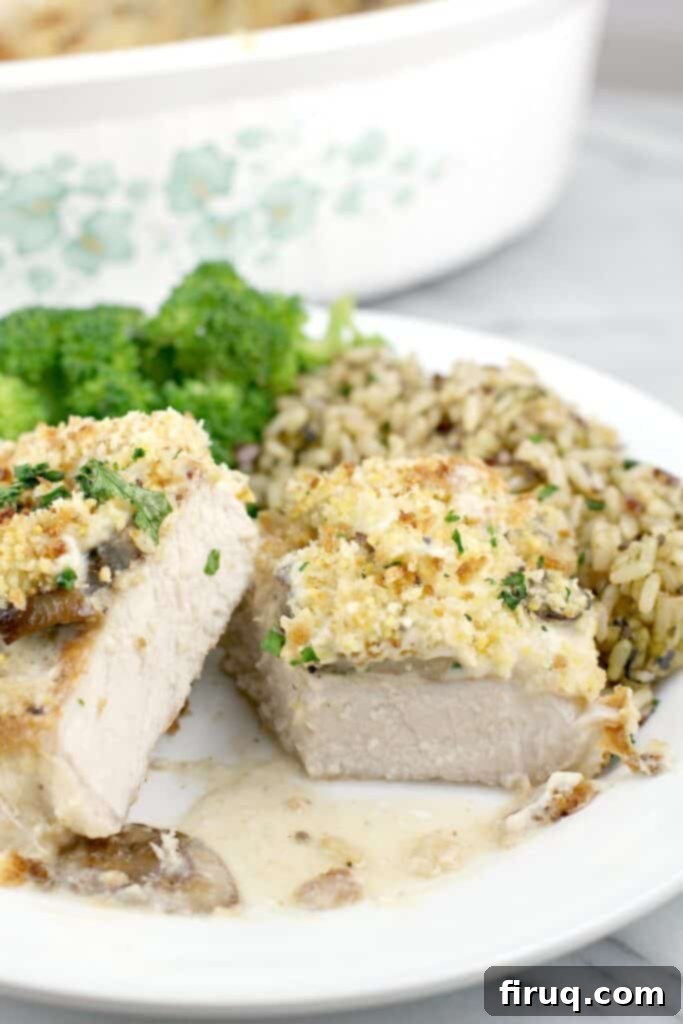 Hearty Pork Chop and Cornbread Bake 13 close front view of finished pork, cut to show doneness plated on serving plate, rice and broccoli in the background