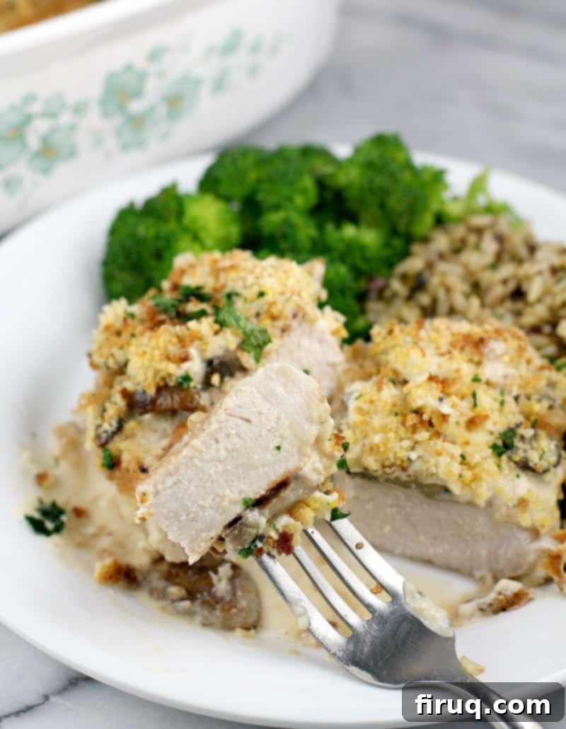 Hearty Pork Chop and Cornbread Bake 15 front view of finished pork, cut to show doneness plated on serving plate, rice and broccoli in the background