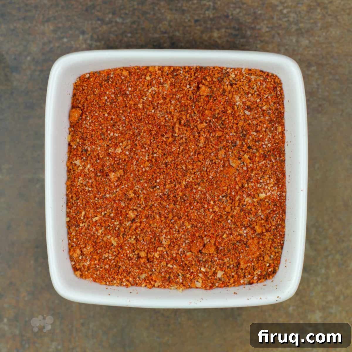 Smoky Pork Grill Rub 2 Homemade pork grill rub in a white square bowl with a brown background, ready for use on barbecue and grilling.
