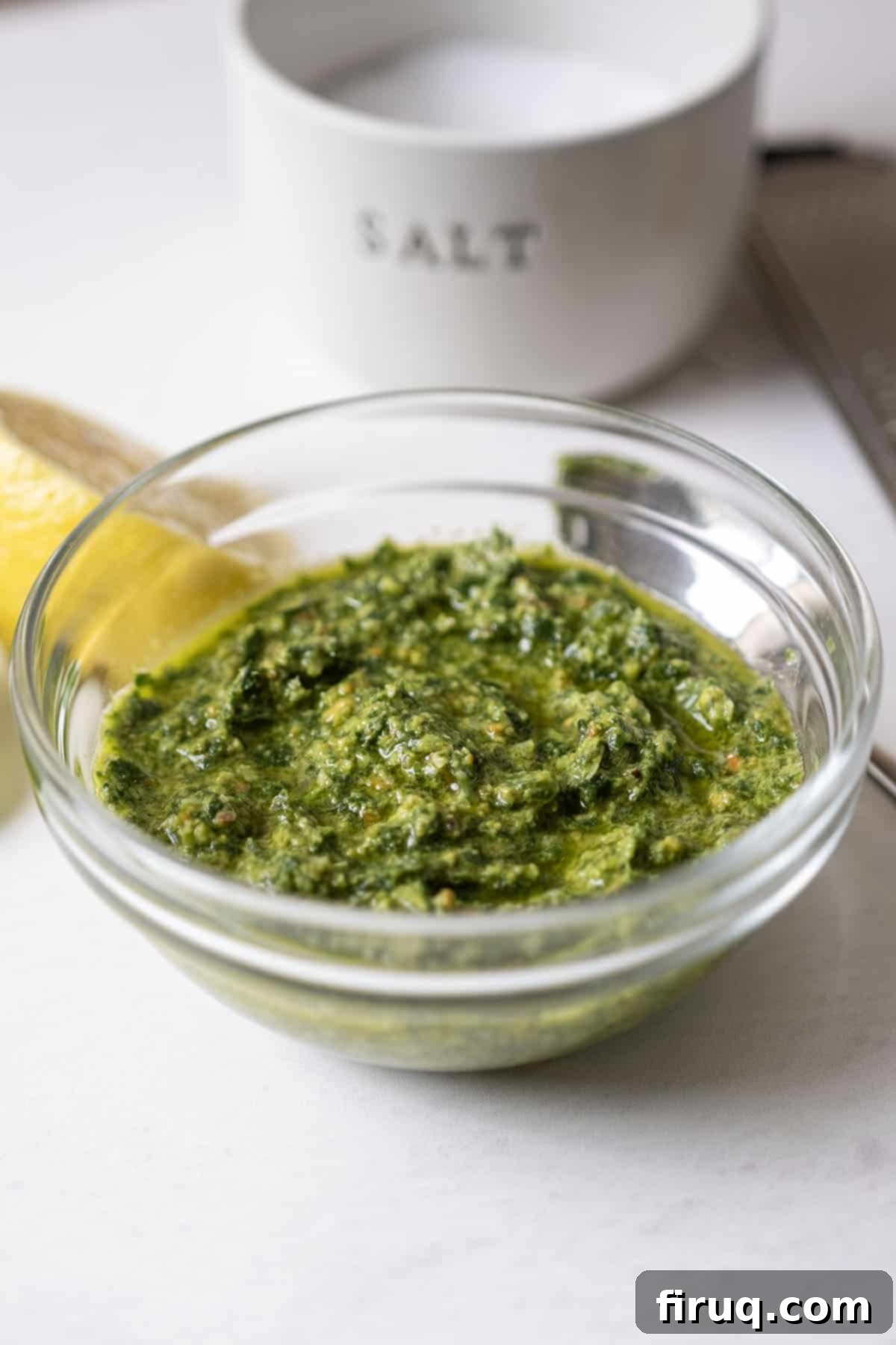 Emerald Pistachio Pesto 2 Pistachio pesto in a bowl, garnished with fresh basil leaves and a few whole pistachios.