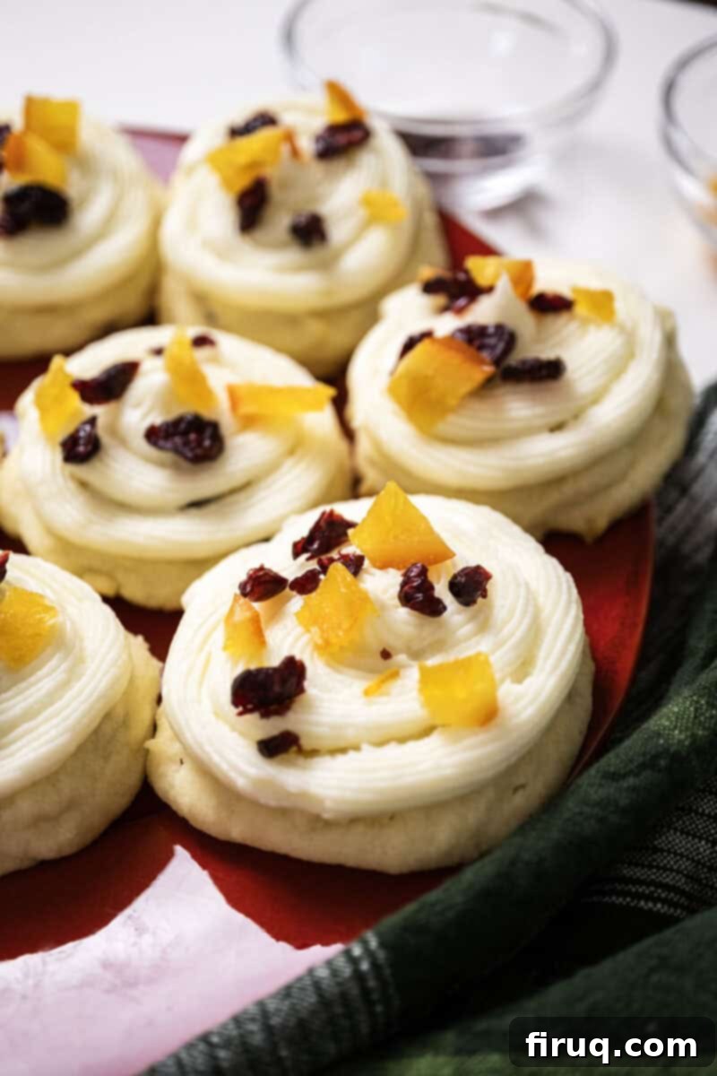 Citrus Cranberry Shortbread Morsels 2 Cranberry and orange shortbread cookies topped with frosting and garnished with dried cranberries and candied oranges.