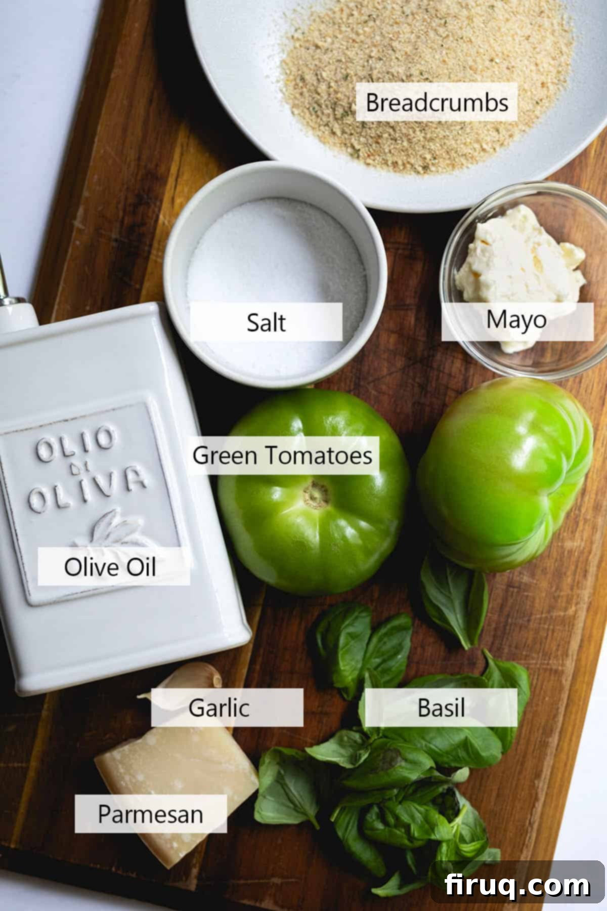 Crispy Italian Fried Green Tomatoes 3 A collection of fresh ingredients laid out for Italian Fried Green Tomatoes, including green tomatoes, basil, garlic, eggs, Parmesan cheese, and breadcrumbs.