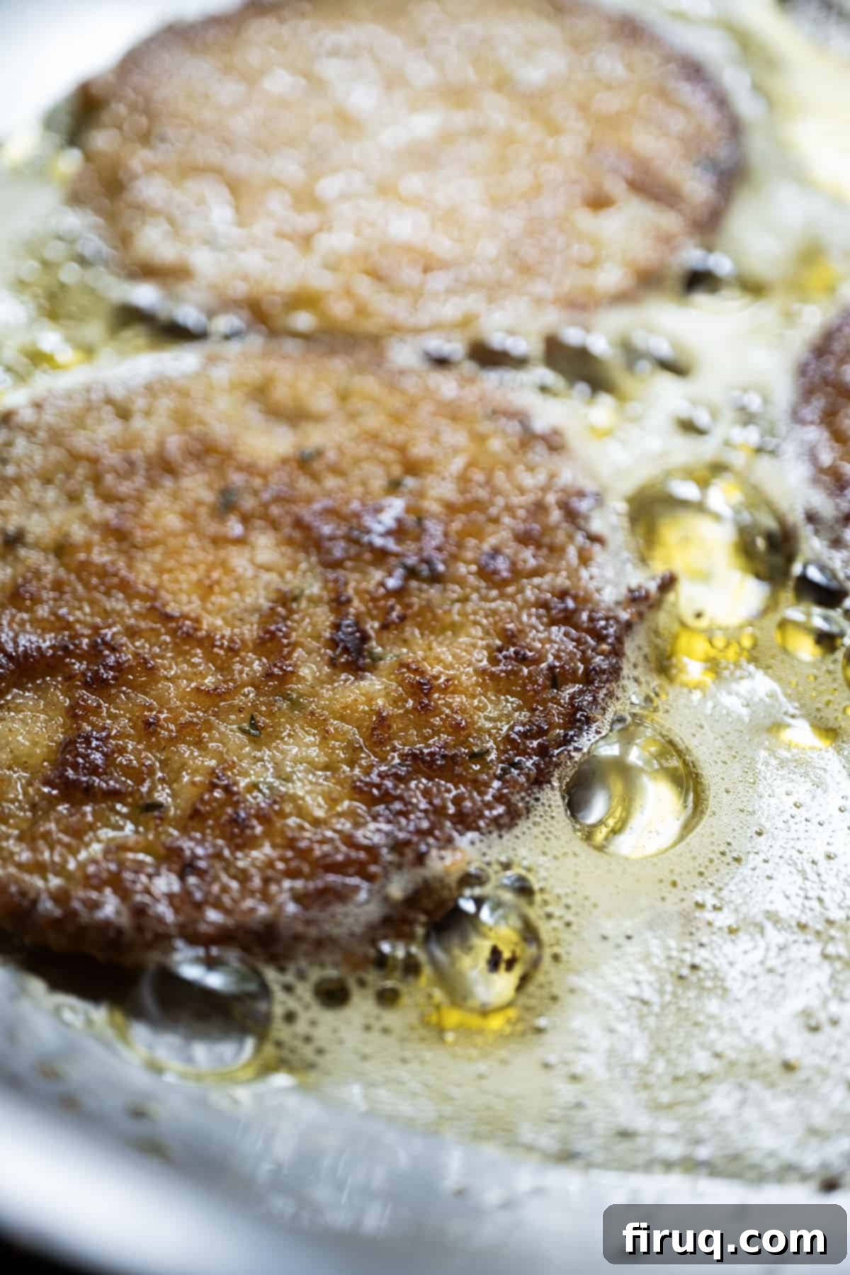 Crispy Italian Fried Green Tomatoes 8 Deliciously golden-brown Italian fried green tomatoes cooling on a wire rack after frying, with visible crispy breading.
