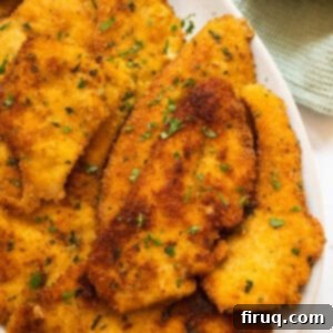Crispy Golden Italian Chicken Cutlets 15 Italian chicken cutlets on piled on a plate.