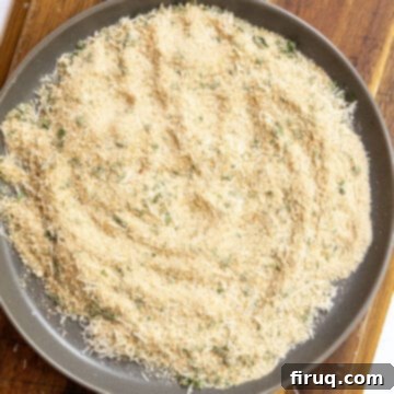 Crispy Golden Italian Chicken Cutlets 4 A plate of seasoned breadcrumbs with fresh parsley and grated Parmesan cheese, ready for breading.