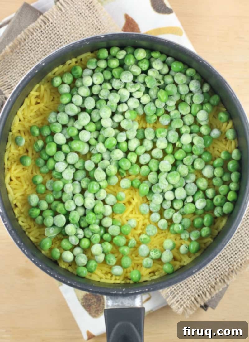 Golden Turmeric Pea Rice 5 peas on cooked rice in a pot