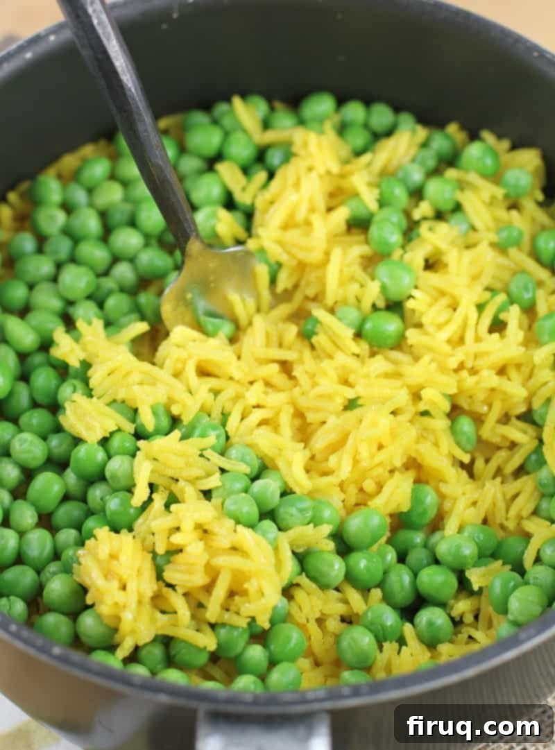 Golden Turmeric Pea Rice 6 fork stirring peas into rice