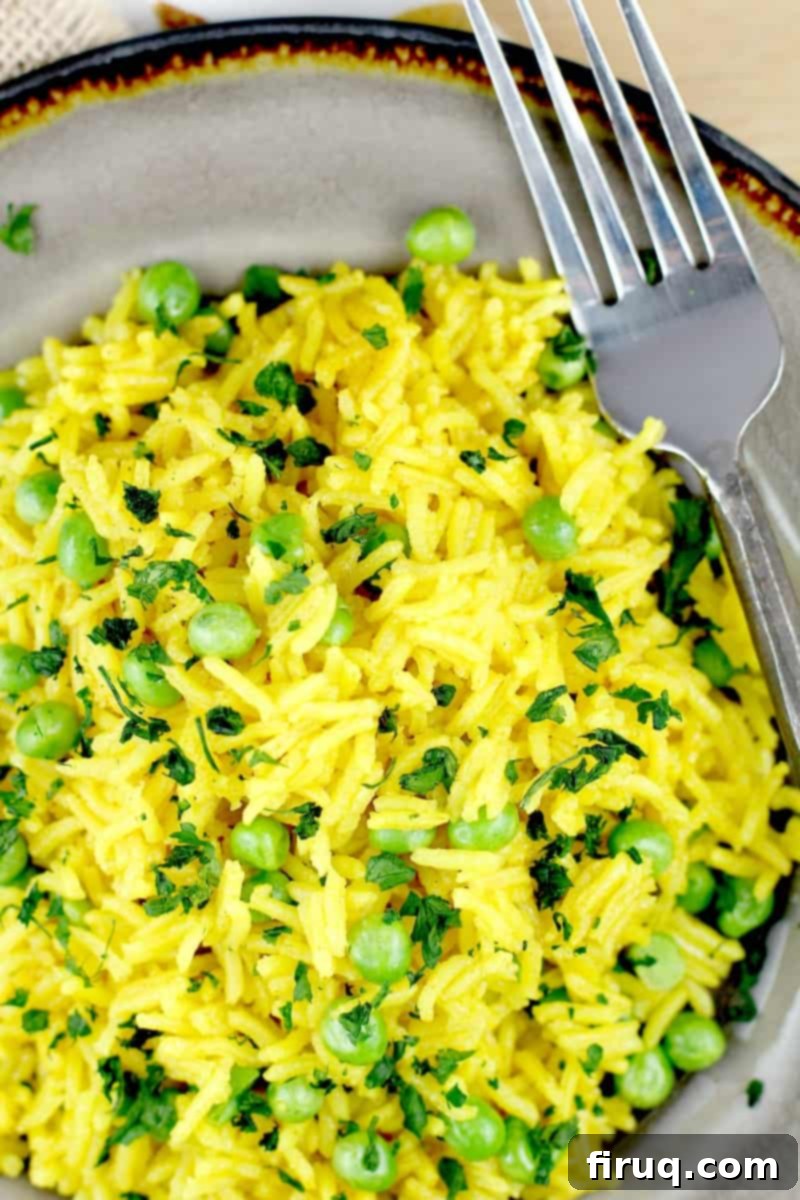 Golden Turmeric Pea Rice 8 top down view of the rice on a plate with a fork on the side