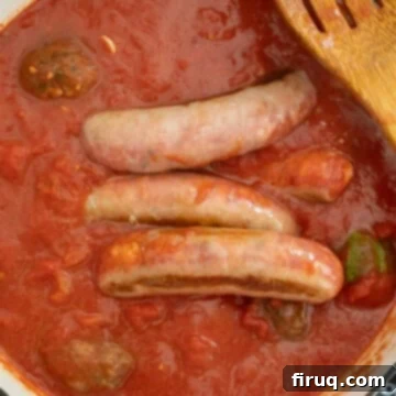 Grandma's Traditional Sunday Gravy 10 Sauce simmering with sausage and meatballs.