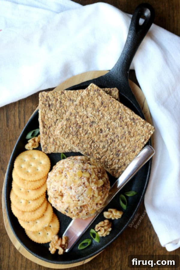 Easy Cheddar Walnut Cheese Ball An overhead photo of a homemade cheese ball and crackers on a serving platter.
