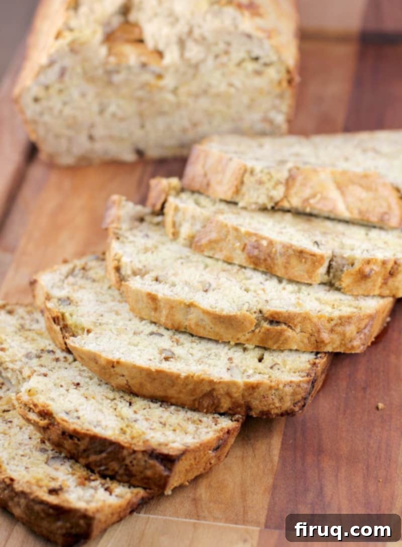 Heirloom Banana Bread 2 Sliced dairy-free banana bread on a rustic cutting board, highlighting its moist texture.