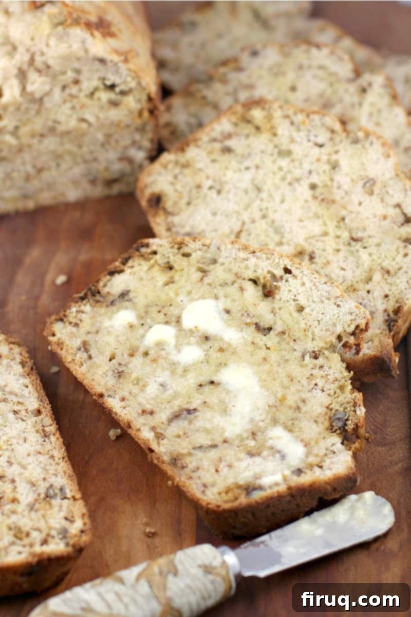 Heirloom Banana Bread 3 A perfectly baked slice of dairy-free banana bread, lightly buttered, showcasing its fluffy texture.