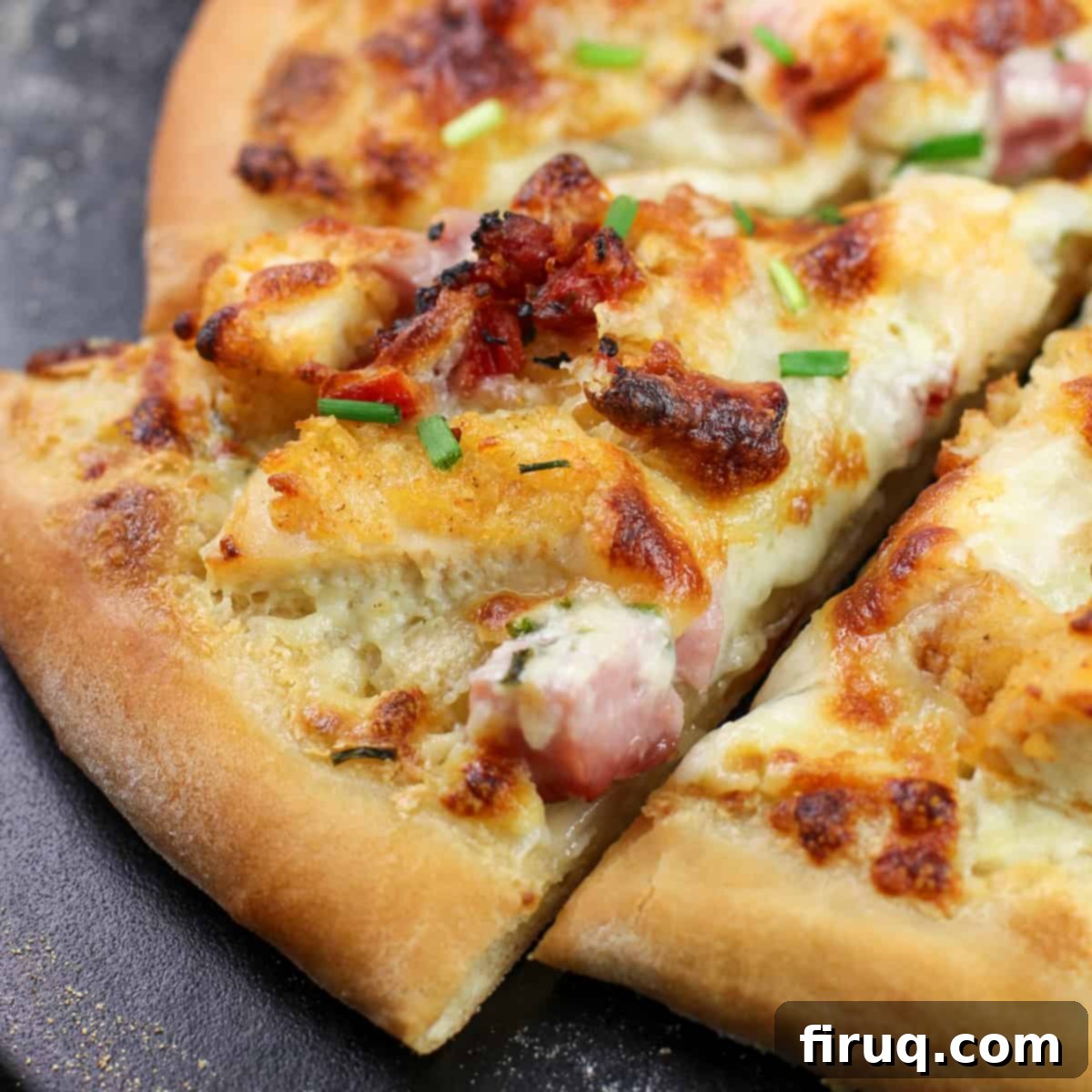 Chicken Cordon Bleu Pizza 4 A single slice of Chicken Cordon Bleu Pizza, perfectly cut and lifted from the pizza stone, showing off its generous toppings and melted cheese.