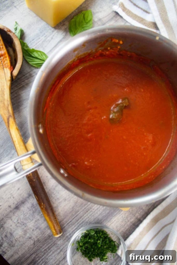 Classic Italian Dishes You Need to Master 4 Sunday Sauce in a Pot with a wooden spoon, fresh parsley, basil and parmesan cheese