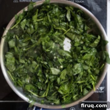 The Ultimate Grilled Stuffed Pork Chops 5 Fresh spinach wilting and cooking down in a saucepan with sauteed garlic, ready to be seasoned for the pork chop stuffing.