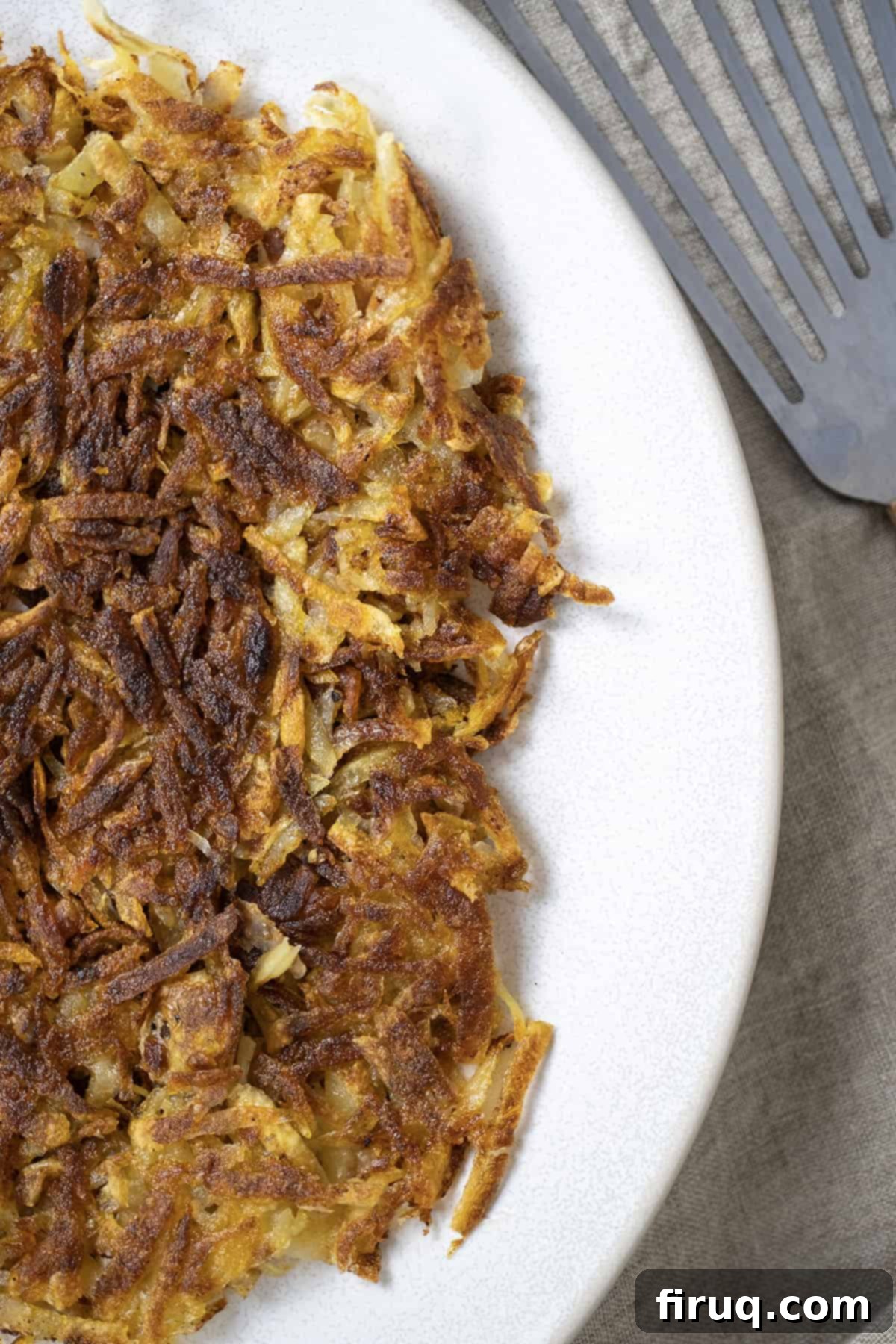 Crispy Hash Browns Perfection 2 Crispy fried hash browns on a plate, ready to be served for breakfast or brunch.