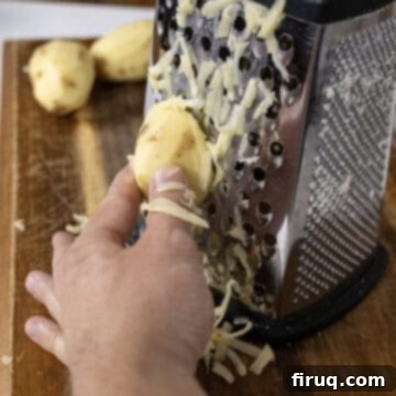 Crispy Hash Browns Perfection 5 Hand grating potatoes using the largest holes of a box grater.