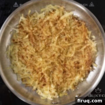 Crispy Hash Browns Perfection 9 Grated hash browns seasoned with paprika, garlic powder, and salt frying in a pan.