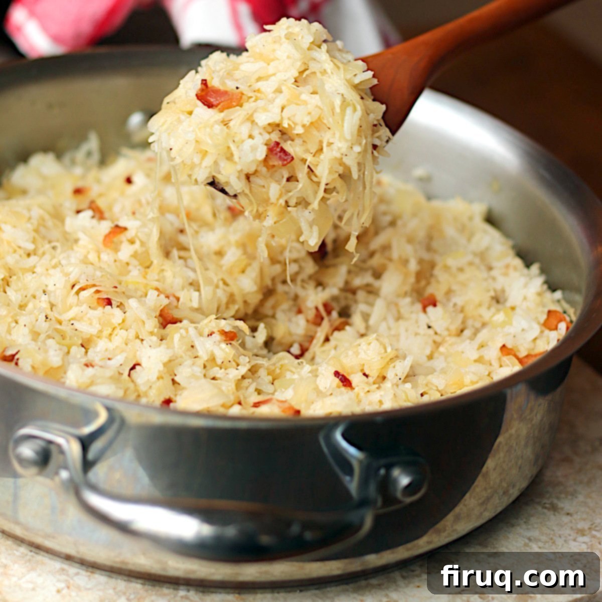 Unstuffed Cabbage Rolls 2 A wooden spoon scooping lazy cabbage rolls from a skillet.