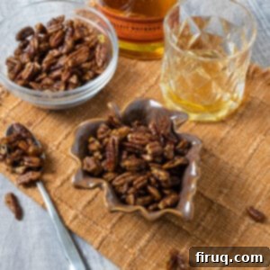 Decadent Bourbon Candied Pecans 9 Candied pecans in 2 separate bowls next to a glass of bourbon. These Bourbon Candied Pecans are a perfect sweet and salty snack for any occasion.