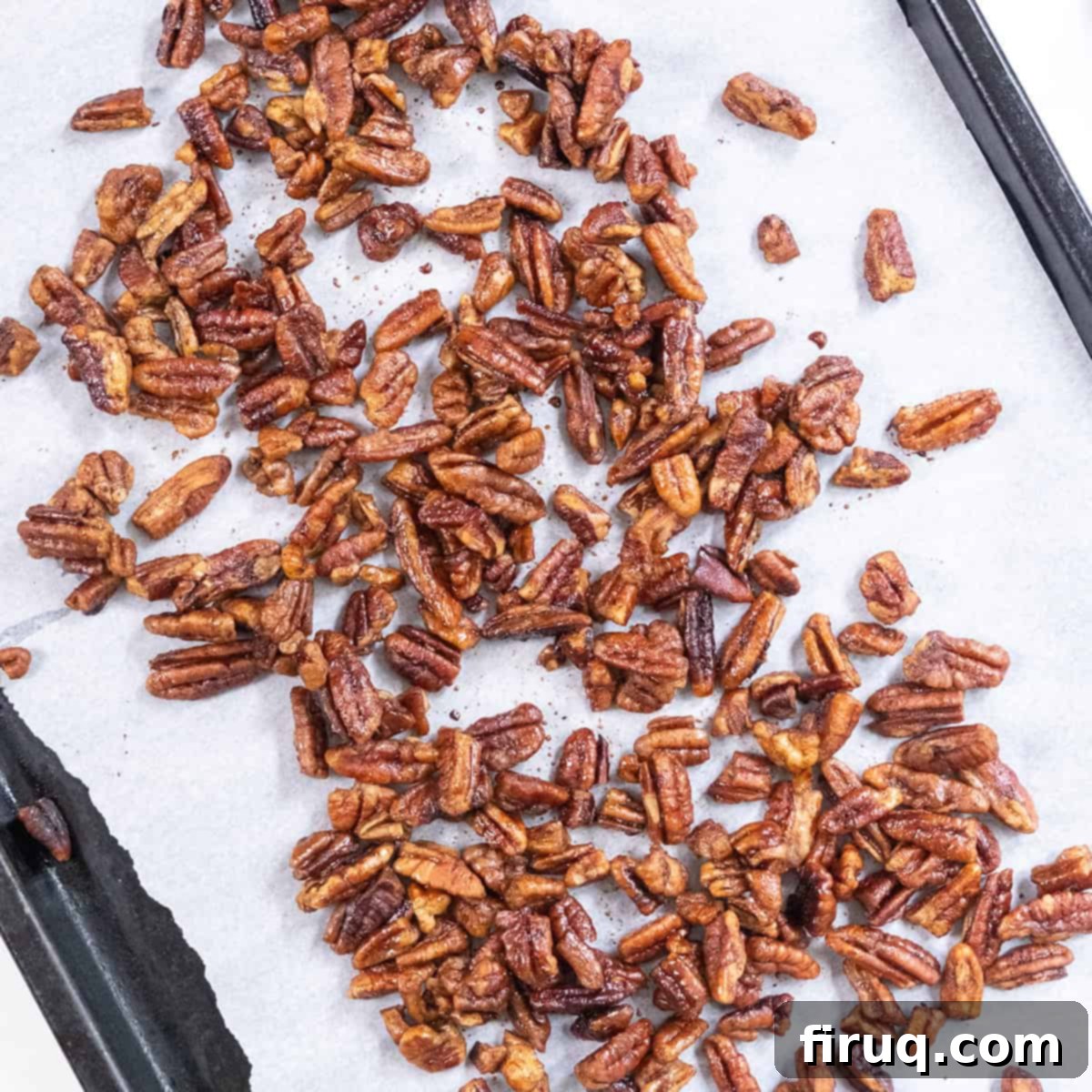 Decadent Bourbon Candied Pecans 8 Pecans laid out on a parchment paper-lined baking tray before baking.