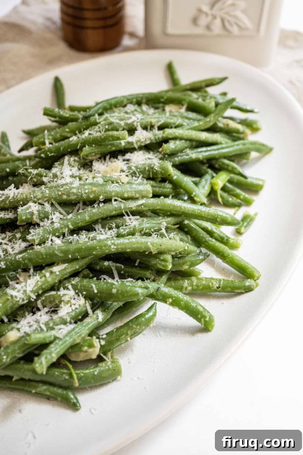 Mouthwatering Garlic Parmesan Green Beans 2 Freshly cooked green beans sprinkled generously with Parmesan cheese, served on a plate, ready to enjoy.
