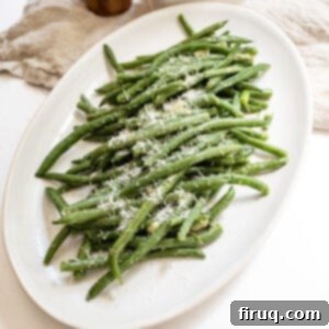 Mouthwatering Garlic Parmesan Green Beans 10 Sauteed green beans with garlic sprinkled with parmesan on a plate.