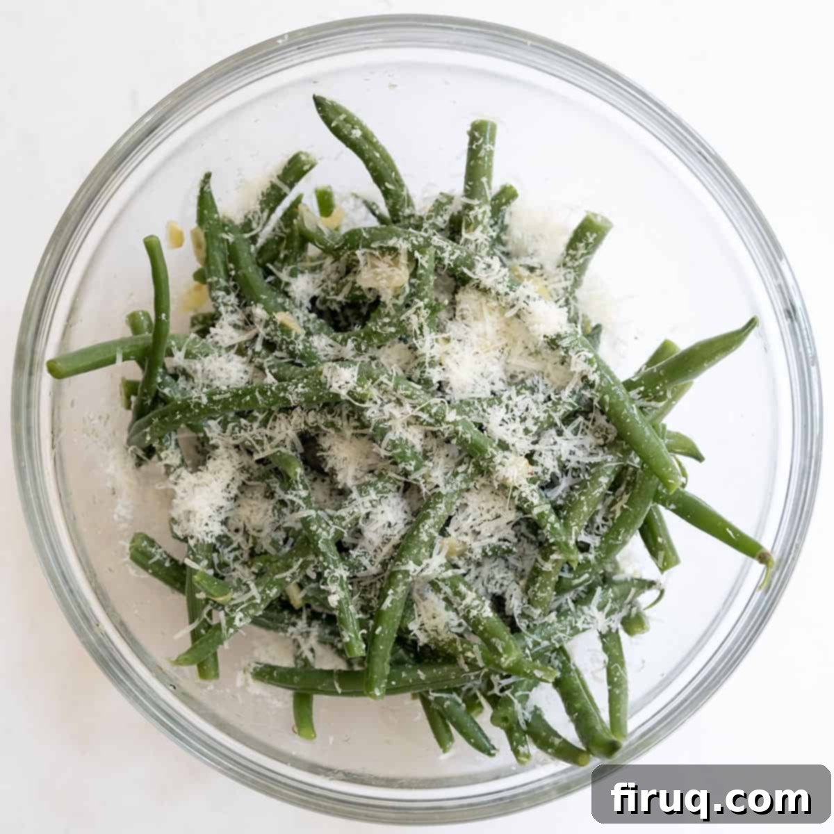 Mouthwatering Garlic Parmesan Green Beans 8 Hot, sautéed green beans being tossed in a bowl with freshly grated Parmesan cheese.