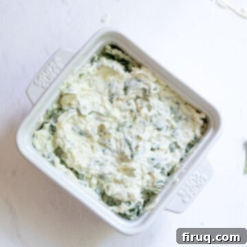 Guilt-Free Creamy Spinach Artichoke Dip 6 Cheese mixture in an oven safe dish.