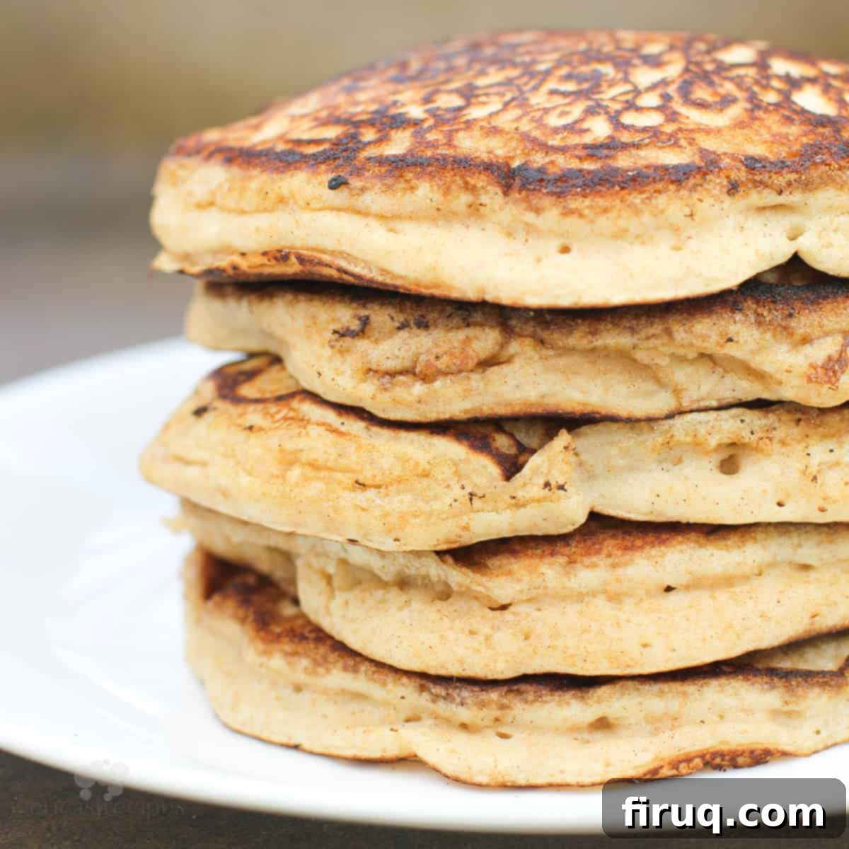 Fluffy Cinnamon Applesauce Pancakes 2 cinnamon applesauce pancakes stacked on white plate, side view