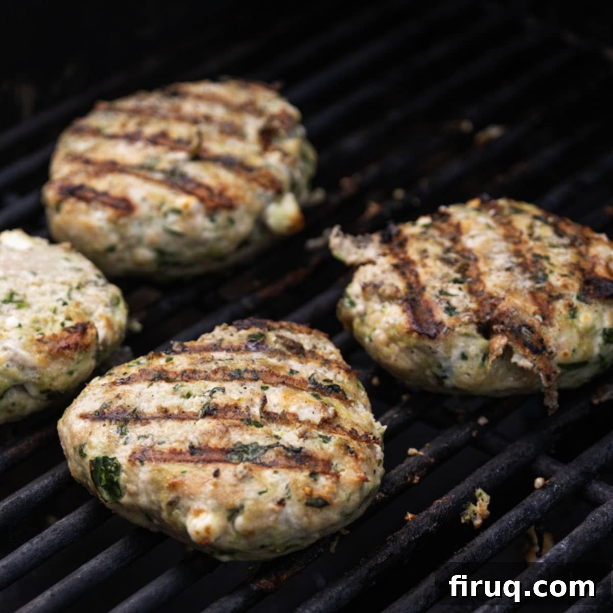 The Olympian Chicken Burger 9 Chicken patties on the grill flipped over with grill marks.