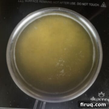 Classic Pastina Carbonara 7 Pastina boiling in a small pot of water on a stovetop.