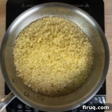 Classic Pastina Carbonara 9 Strained pastina and a ladleful of pasta water being added to the pan with sautéed garlic.