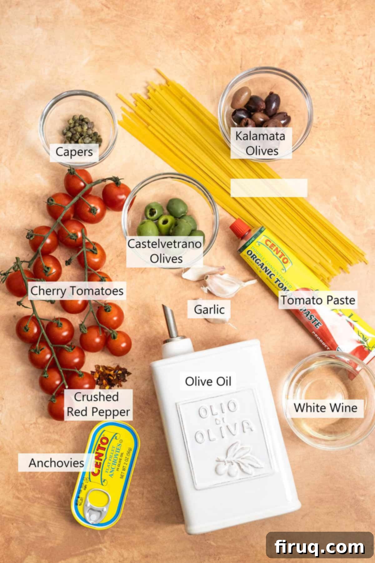 Rustic Linguine Alla Puttanesca 3 Ingredients for the recipe laid out on a wooden board, including fresh cherry tomatoes, garlic, olives, capers, anchovies, and a bottle of olive oil.