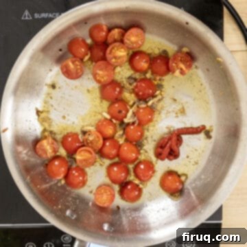 Rustic Linguine Alla Puttanesca 6 Halved cherry tomatoes breaking down and releasing their juices with garlic and anchovies in a pan, forming the base of the sauce.