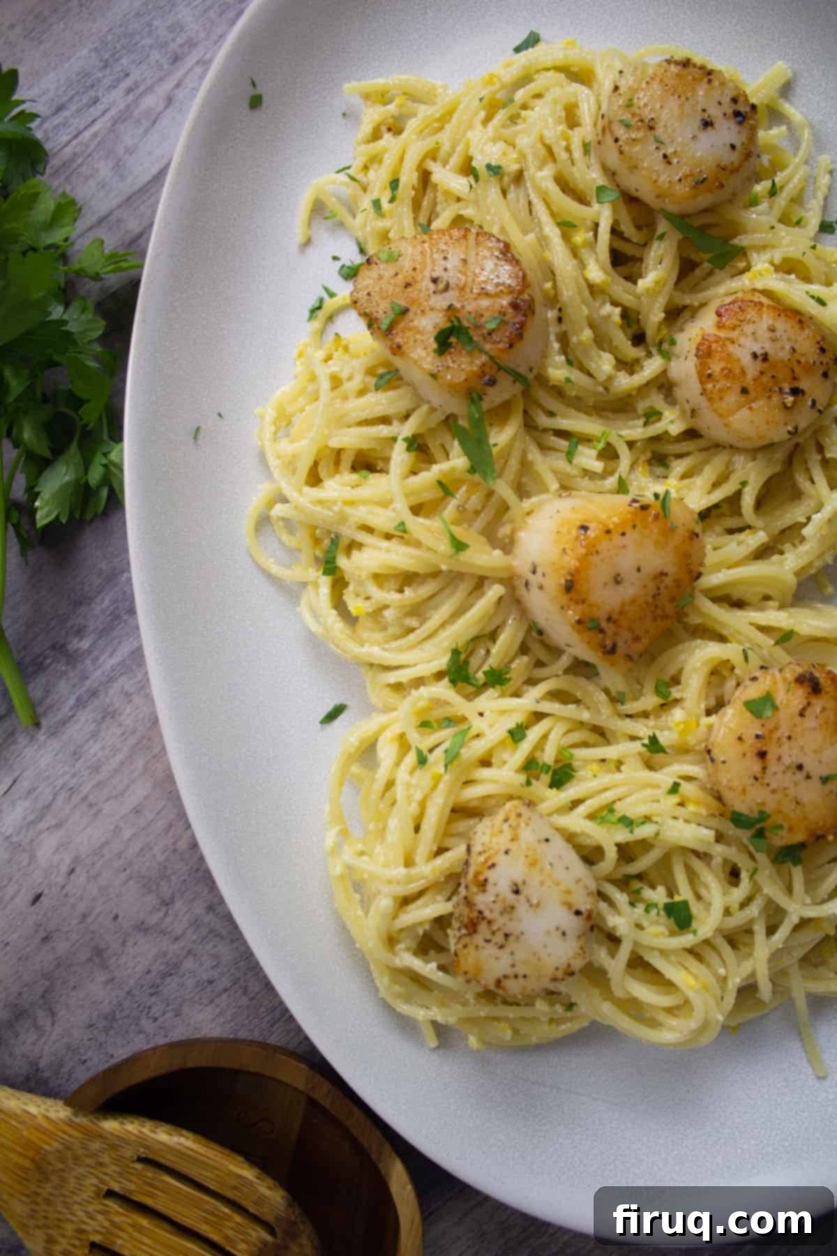 Bright Lemon Pesto Spaghetti with Pan-Seared Scallops 3 Lemon pesto spaghetti with perfectly seared scallops, garnished with fresh chopped parsley and a lemon wedge