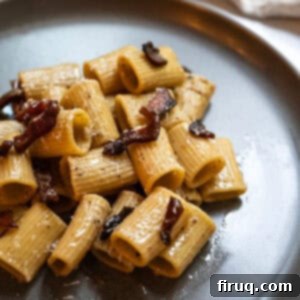 Roman Guanciale Pasta 13 Pasta alla gricia served on a plate and topped with guanciale.