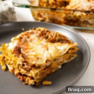The Ultimate Homemade Italian Lasagna 15 A square of authentic Italian lasagna, perfectly portioned and plated, showcasing its rich layers of pasta, meat sauce, and creamy ricotta, topped with melted cheese.
