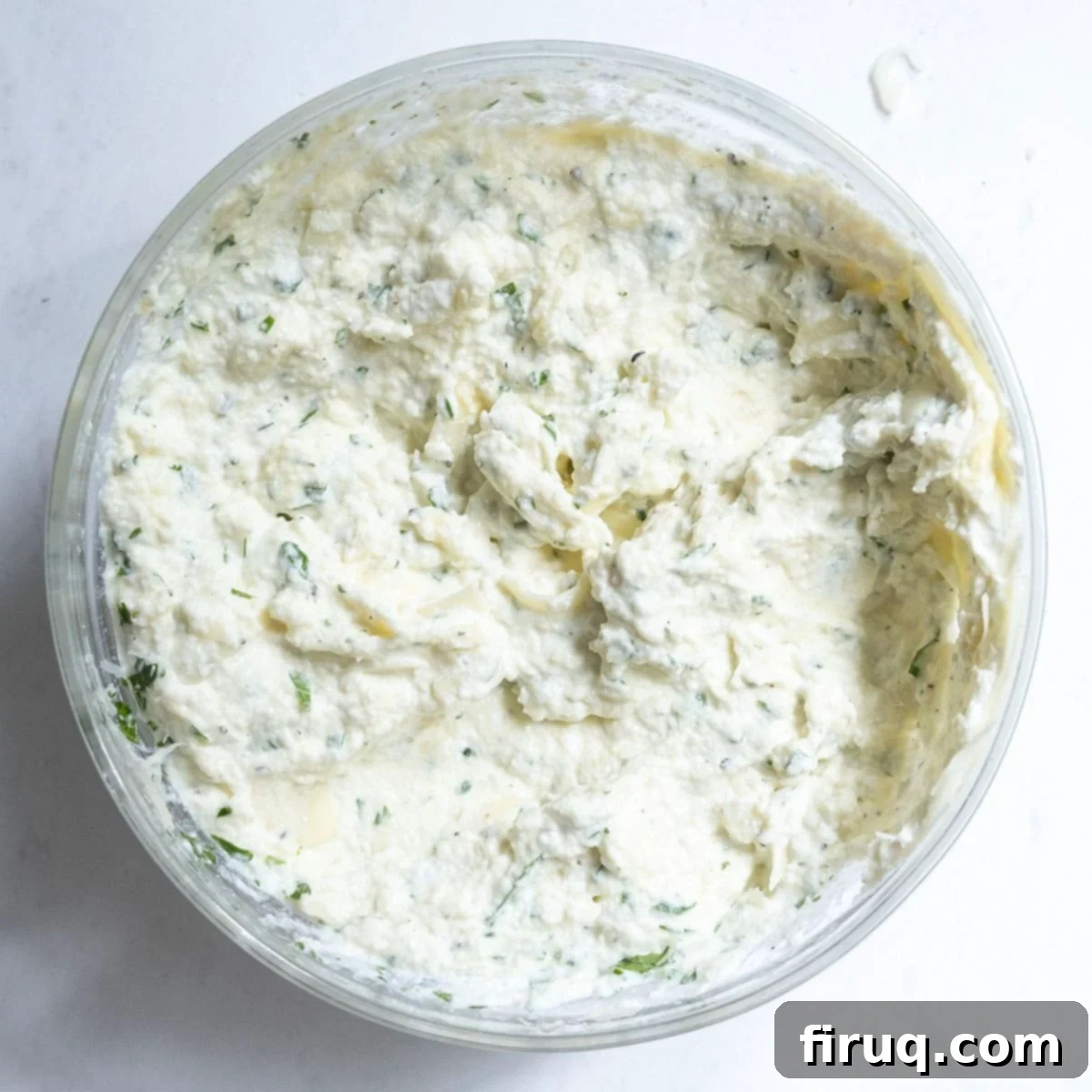 The Ultimate Homemade Italian Lasagna 4 A bowl of creamy ricotta combined with eggs, parmesan cheese, mozzarella, and a generous sprinkle of fresh herbs, showcasing the perfectly seasoned mixture for lasagna.