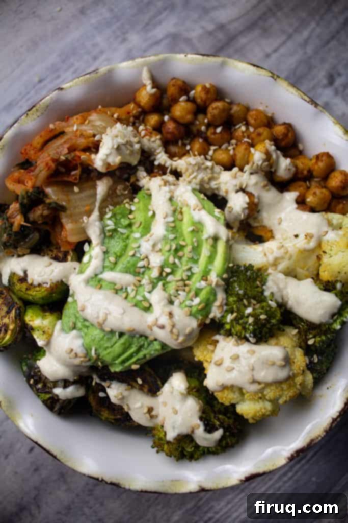 Crispy Chickpea Power Bowl 4 Complete grain bowl featuring a colorful array of vegetables, roasted chickpeas, lemon tahini dressing, fresh avocado, tangy kimchi, and sesame seeds