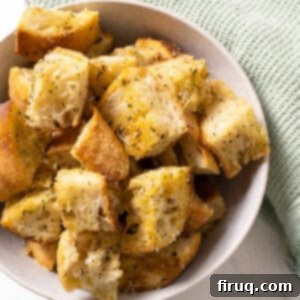 Crispy Homemade Parmesan Croutons 10 A close-up of crispy, golden Homemade Italian Parmesan Croutons in a white bowl.