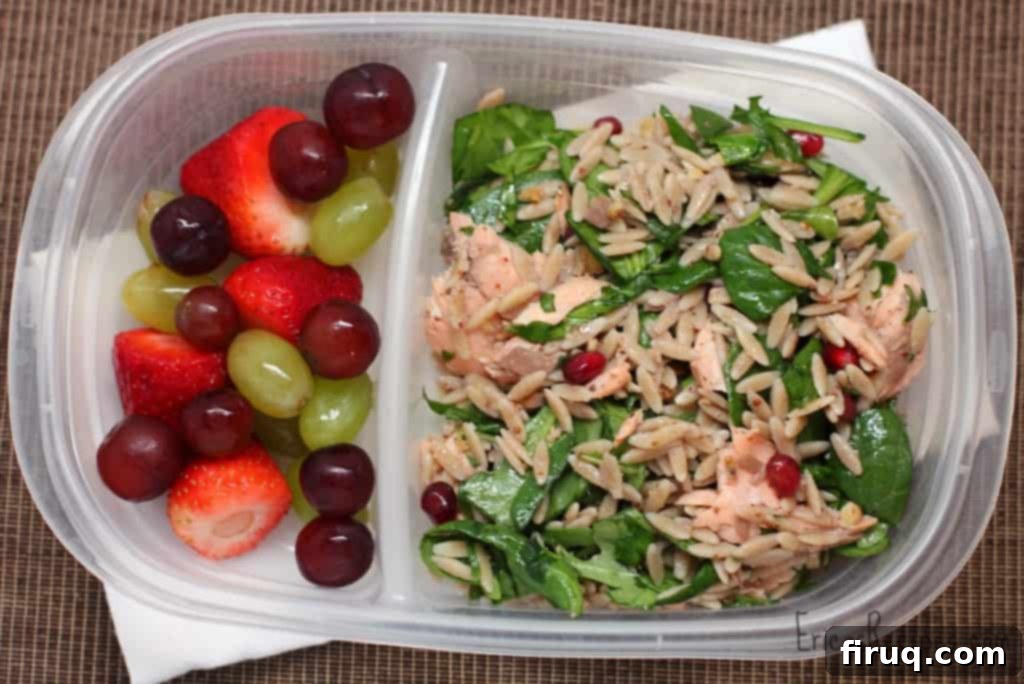 Close-up of Orzo Power Salad featuring salmon, walnuts, greens, and pomegranate seeds