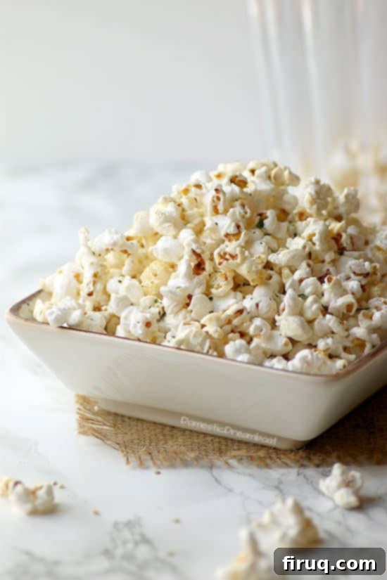 Miso Butter Popcorn A close-up shot of Miso Butter Popcorn in a bowl, showing the golden kernels coated in miso butter, with some green flakes of seasoning.