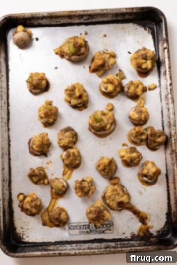 Gourmet Italian Sausage Stuffed Mushrooms 10 Baked stuffed mushrooms on a baking sheet.