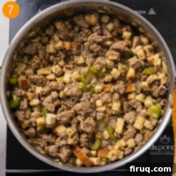 Robust Italian Sausage Thanksgiving Stuffing 8 Chicken broth being poured over bread stuffing cubes and sausage in a saucepan to moisten and soften the bread.