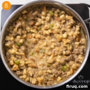 Robust Italian Sausage Thanksgiving Stuffing 9 Fully combined bread cubes, chicken broth, browned Italian sausage, and sautéed vegetables stirred together in a large saucepan, creating a creamy stuffing mixture.