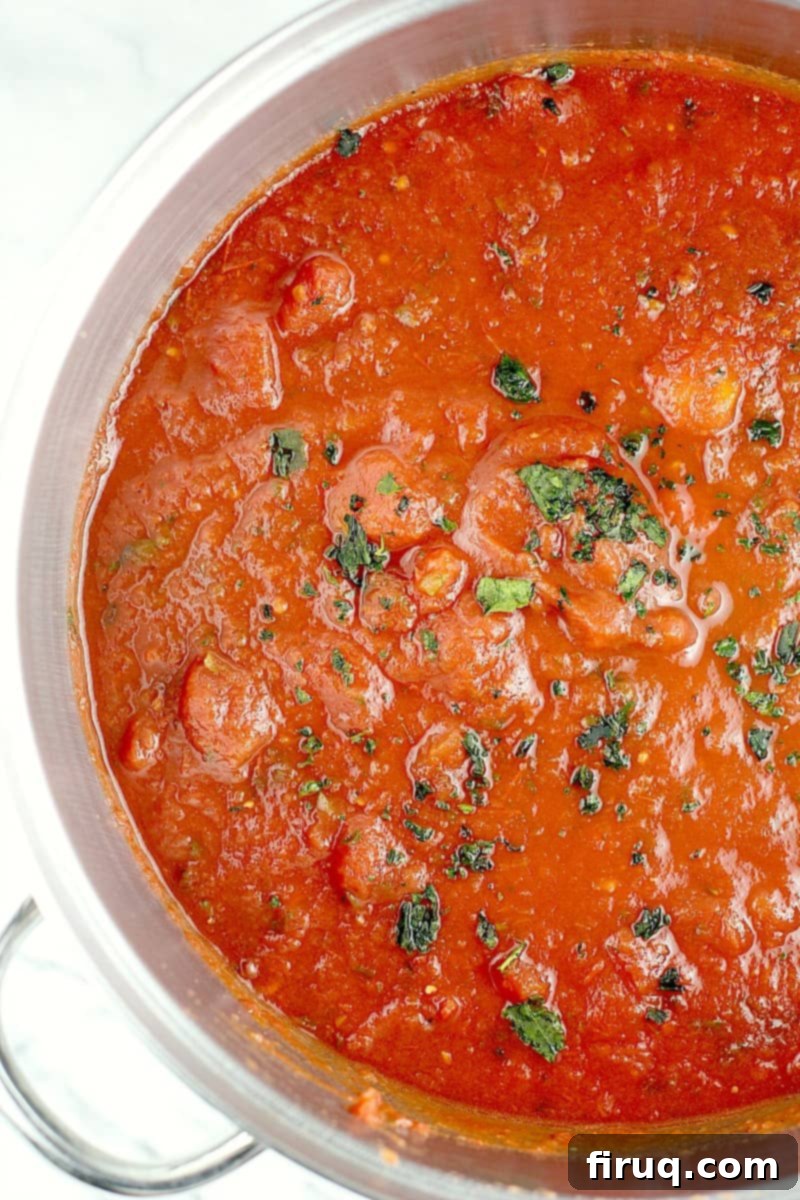 The Best Homemade Marinara 3 Top down view into the pot to show the finished canned tomatoes sauce; fresh herb is sprinkled on top