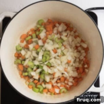 Creamy Chicken Tortellini Bliss 6 Sauteing chopped carrots, celery, and onion in a pot for soup.
