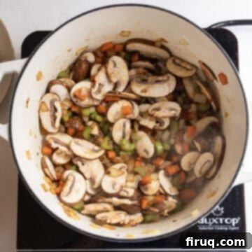 Creamy Chicken Tortellini Bliss 8 Sliced mushrooms sauteing with the mixed vegetables in the pot.